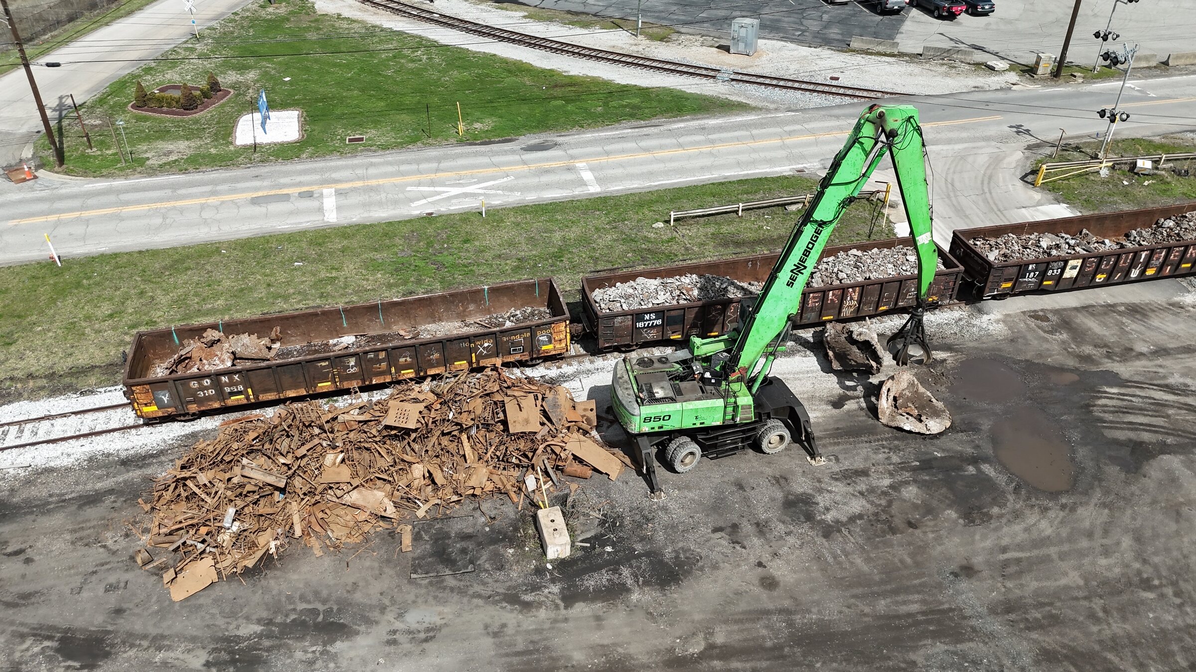 Aerial view of a SENNEBOGEN 850 material handler loading scrap into rail cars on Santoro's Weirton siding