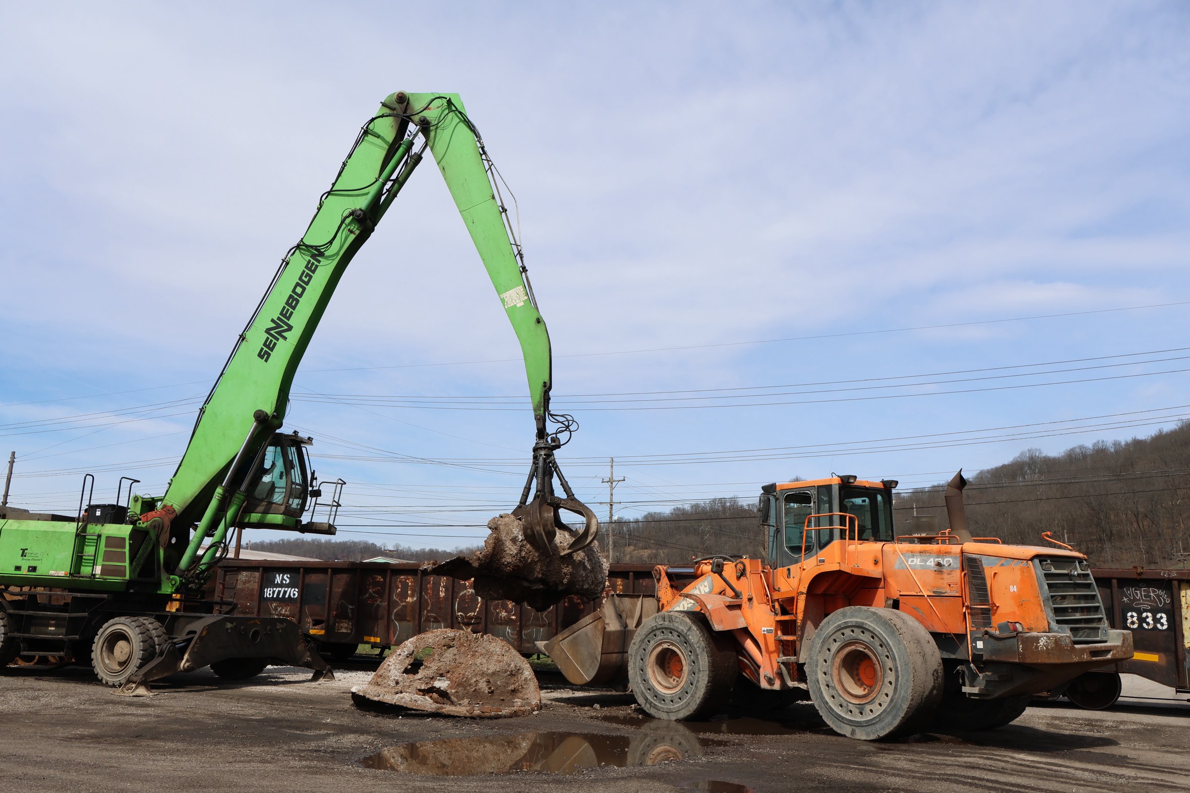 SENNEBOGEN material handler lifting scrap beside a wheel loader at the Weirton yard